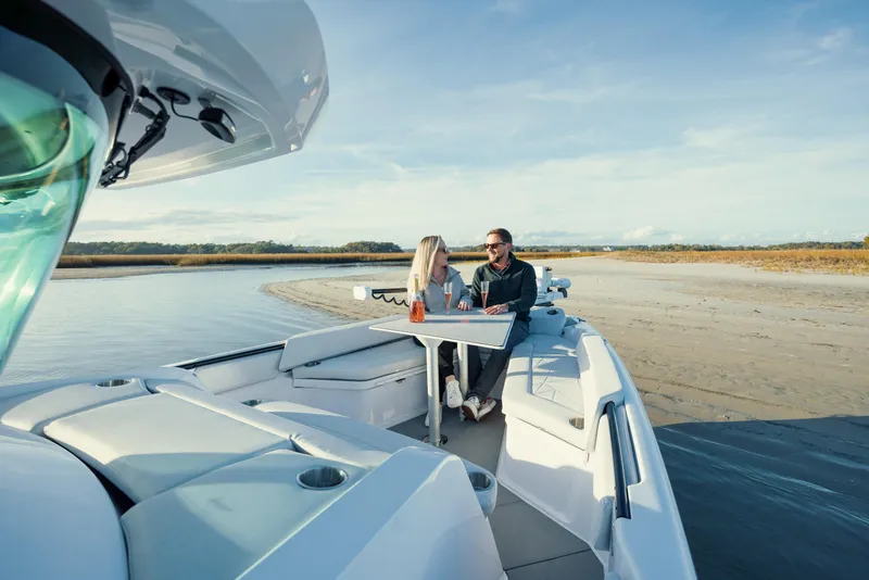 Slide: The Image of 2026 Axopar AX29 CCX boat cruising on calm waters near a city shoreline. - 9