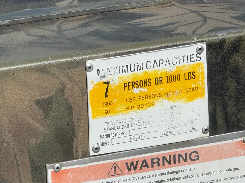 Slide: The Image of 2022 Lowe Roughneck RX2070 Tiller capacity label, 7 persons or 1000 lbs, warning notice. - 13