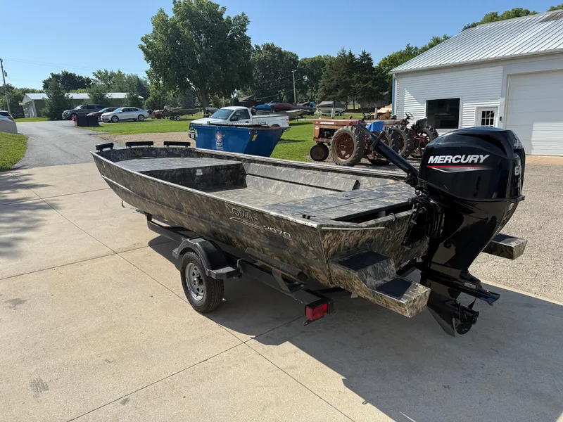 Slide: The Image of 2022 Lowe Roughneck RX2070 Tiller boat with Mercury engine on a trailer, parked outdoors. - 5