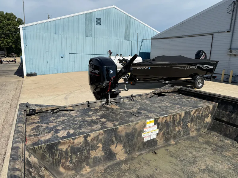 Slide: The Image of 2022 Lowe Roughneck RX2070 Tiller boat with camouflage design and Mercury outboard motor. - 9