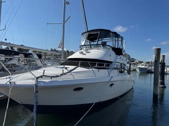 Slide: The Image of 2001 Silverton 35 Convertible yacht docked in a marina under clear blue skies. - 1