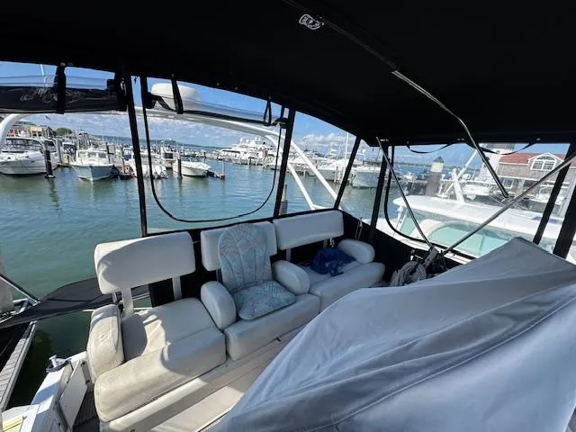 Slide: The Image of 2001 Silverton 35 Convertible boat interior with marina view, featuring comfortable seating. - 10