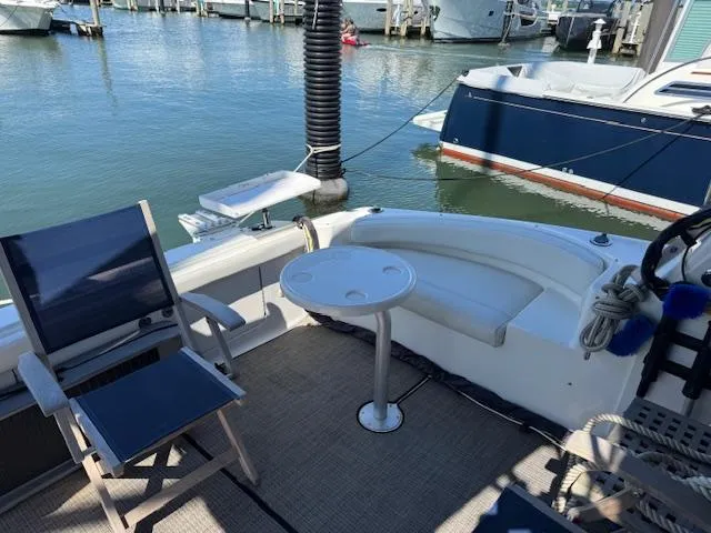 Slide: The Image of 2001 Silverton 35 Convertible yacht deck with seating and table, docked at marina. - 13