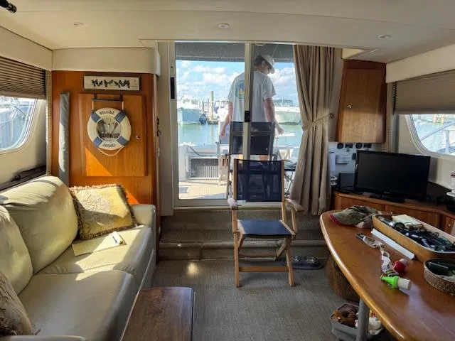 Slide: The Image of Interior of a 2001 Silverton 35 Convertible yacht with cozy seating and marina view. - 14