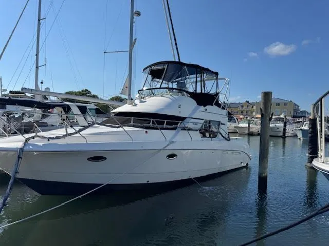 Slide: The Image of 2001 Silverton 35 Convertible yacht docked in a marina under clear blue skies. - 2