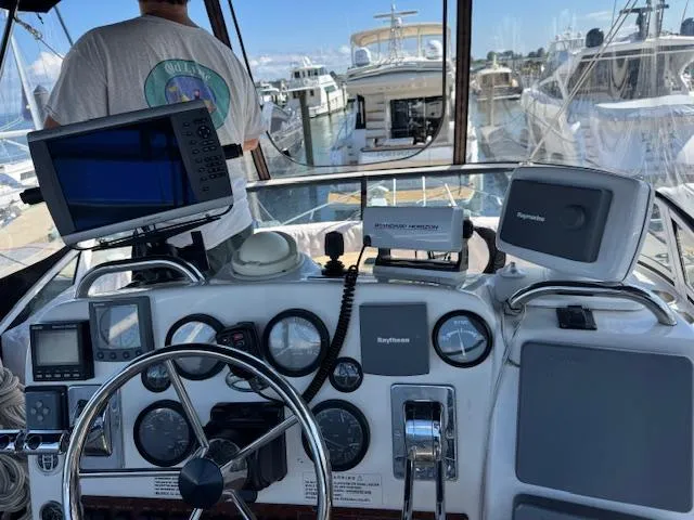 Slide: The Image of Helm of 2001 Silverton 35 Convertible with navigation equipment and marina view. - 6
