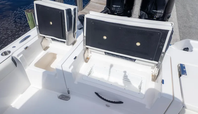 Slide: The Image of 2025 Tidewater 3100 Carolina Bay boat with open storage compartments and dual Verado engines. - 11