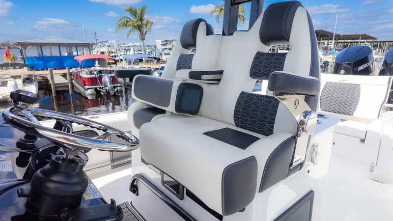 Slide: The Image of 2025 Tidewater 3100 Carolina Bay boat interior with modern seating and steering wheel. - 15