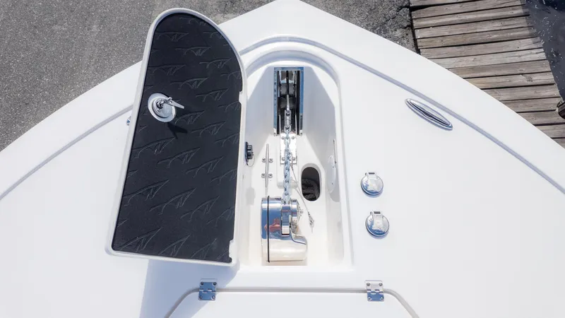 Slide: The Image of 2025 Tidewater 3100 Carolina Bay boat anchor compartment with open hatch and chain mechanism. - 23