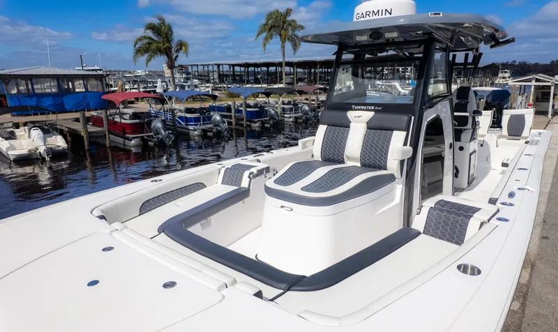 Slide: The Image of 2025 Tidewater 3100 Carolina Bay boat docked at marina with palm trees. - 3