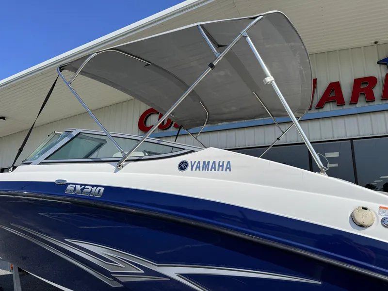 Slide: The Image of 2012 Yamaha SX210 boat with canopy, displayed outside a showroom. - 4