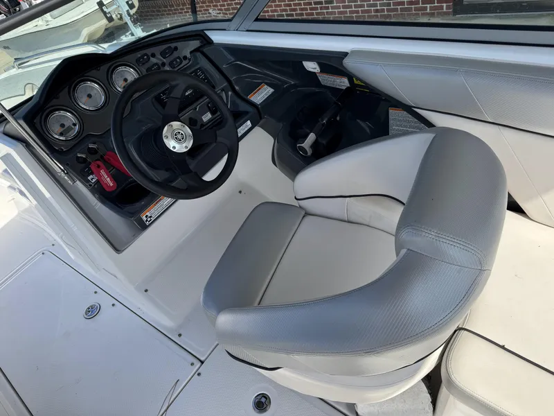 Slide: The Image of 2012 Yamaha Boats SX210 cockpit with steering wheel and gauges, featuring gray seating. - 9