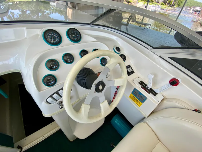 Slide: The Image of 1999 Checkmate 259 Convincer boat dashboard with steering wheel and gauges. - 13