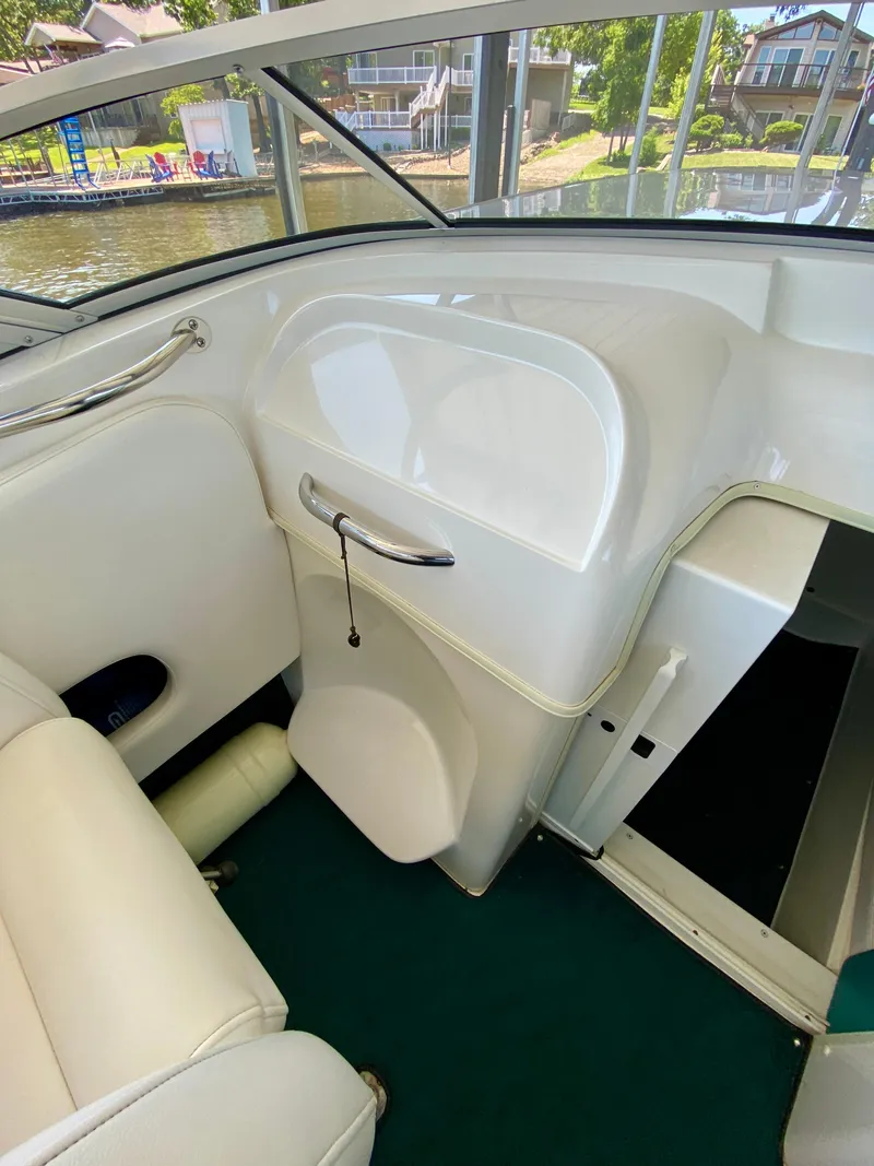 Slide: The Image of Interior of a 1999 Checkmate 259 Convincer boat with white seating and green carpet. - 19