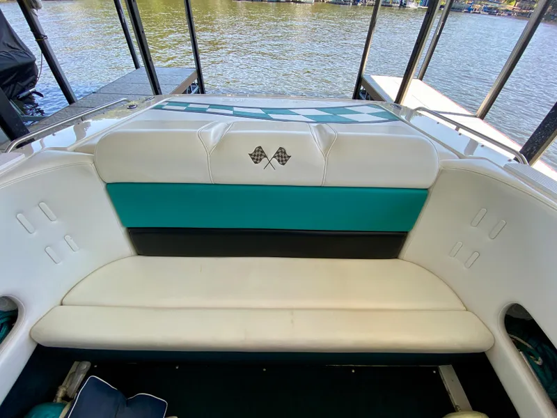 Slide: The Image of 1999 Checkmate 259 Convincer boat interior with white and teal seating, checkered flag design. - 20