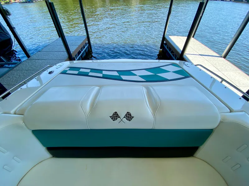 Slide: The Image of 1999 Checkmate 259 Convincer boat interior with checkered design, docked by a lake. - 21