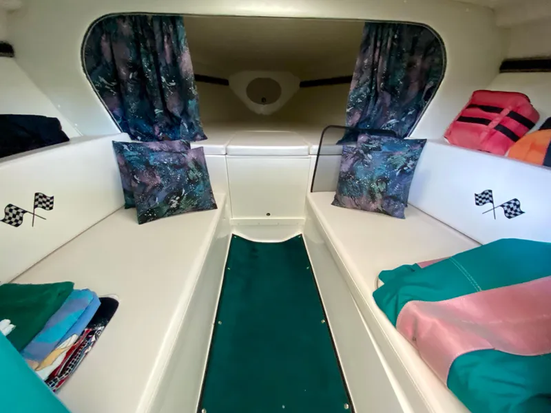 Slide: The Image of Interior of 1999 Checkmate 259 Convincer boat with colorful cushions and curtains. - 23