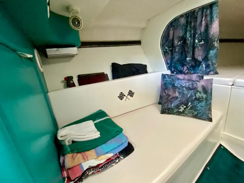 Slide: The Image of Interior of 1999 Checkmate 259 Convincer boat with colorful cushions and folded towels. - 24