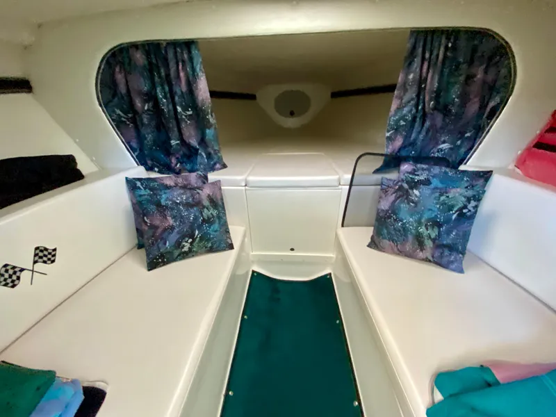 Slide: The Image of 1999 Checkmate 259 Convincer cabin interior with patterned cushions and curtains. - 25