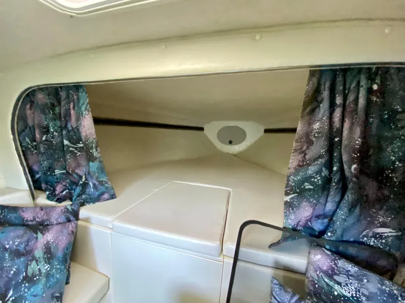 Slide: The Image of 1999 Checkmate 259 Convincer cabin interior with patterned curtains and white seating. - 26