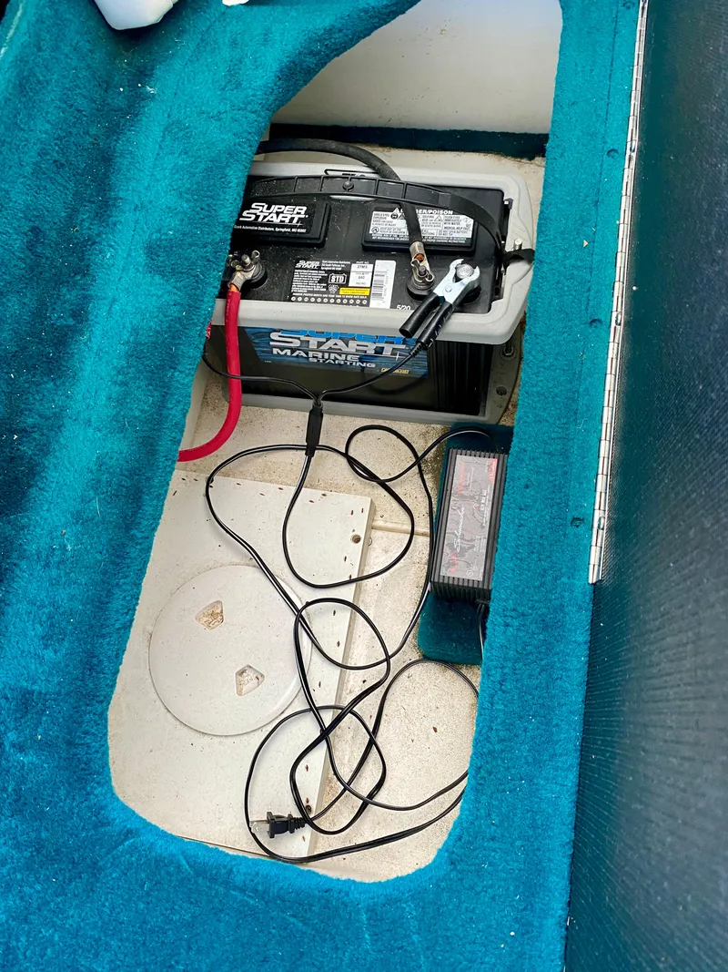 Slide: The Image of Battery compartment of 1999 Checkmate 259 Convincer boat with marine battery and charger. - 32
