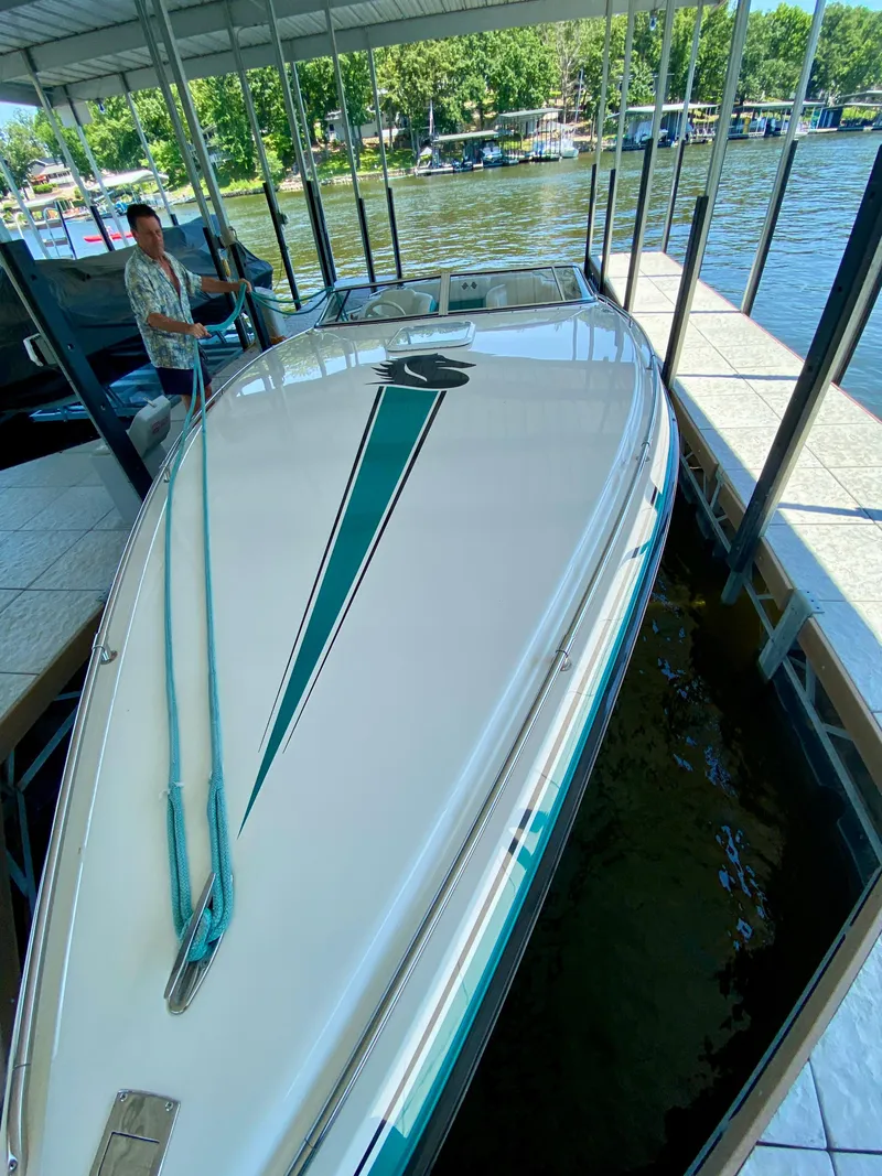 Slide: The Image of 1999 Checkmate 259 Convincer boat docked, featuring sleek design and vibrant graphics. - 7