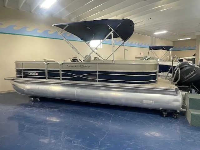 Slide: The Image of 2019 South Bay 224 RS 3.0 pontoon boat with canopy in showroom. - 2