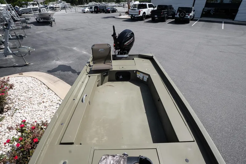 Slide: The Image of 2023 Tracker Grizzly 1654 T Sportsman boat in parking lot, showcasing interior and motor. - 12
