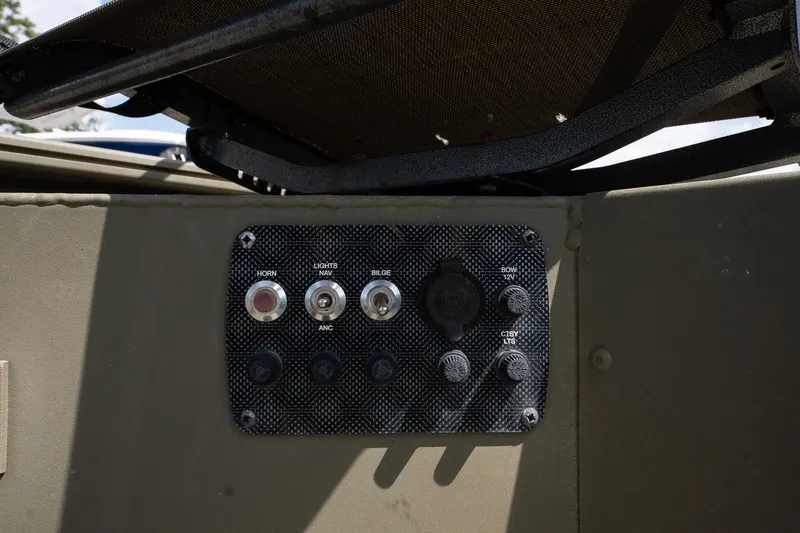 Slide: The Image of Control panel of 2023 Tracker Grizzly 1654 T Sportsman boat with switches and buttons. - 13