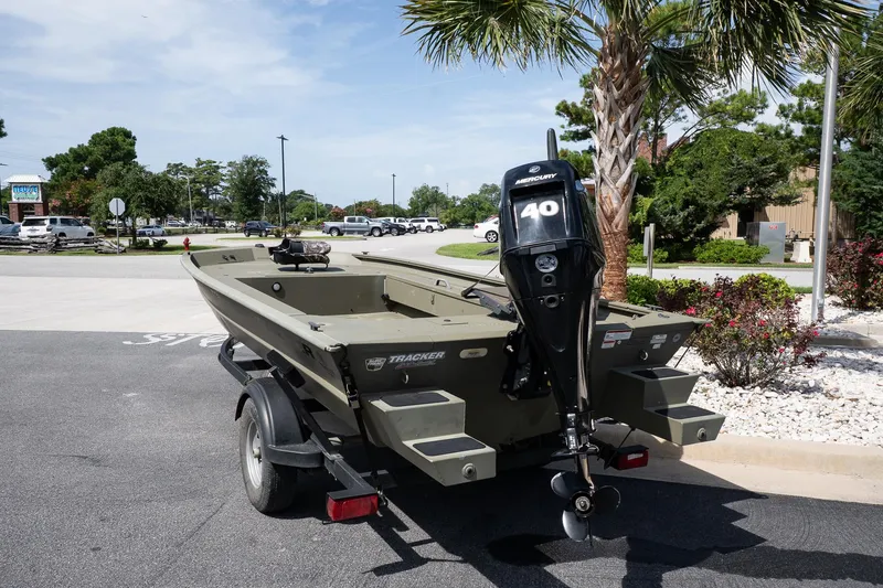 Slide: The Image of 2023 Tracker Grizzly 1654 T Sportsman boat on trailer, parked outdoors. - 2