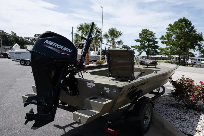 Slide: The Image of 2023 Tracker Grizzly 1654 T Sportsman boat with Mercury engine in a parking lot. - 3