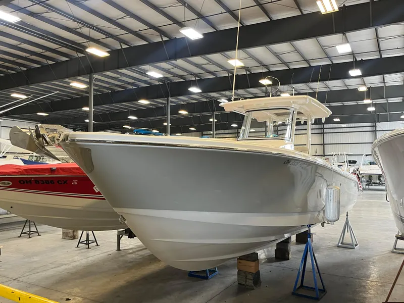 The Image of 2020 Edgewater 320CC boat in a spacious indoor showroom. - 0