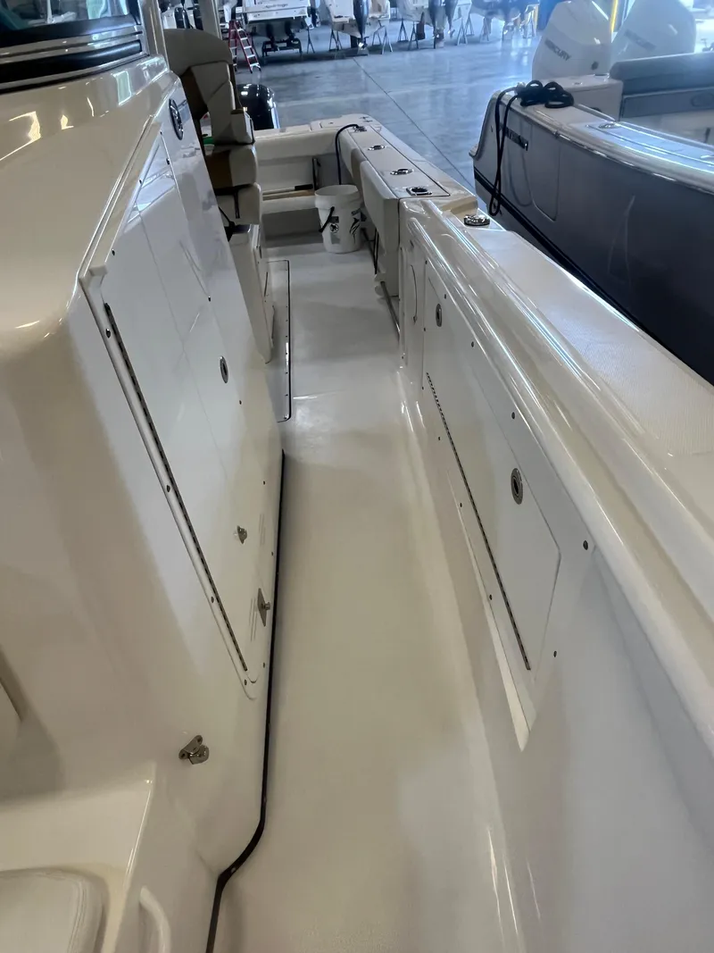 Slide: The Image of 2020 Edgewater 320CC boat interior, showcasing sleek white deck and storage compartments. - 10