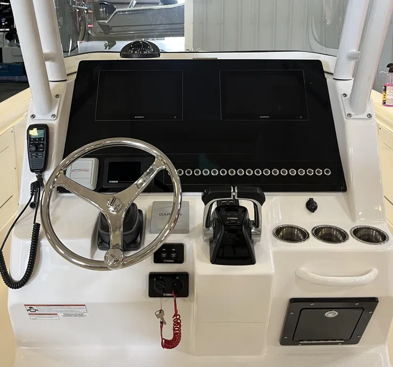 Slide: The Image of 2020 Edgewater 320CC boat console with steering wheel, dual screens, and controls. - 13