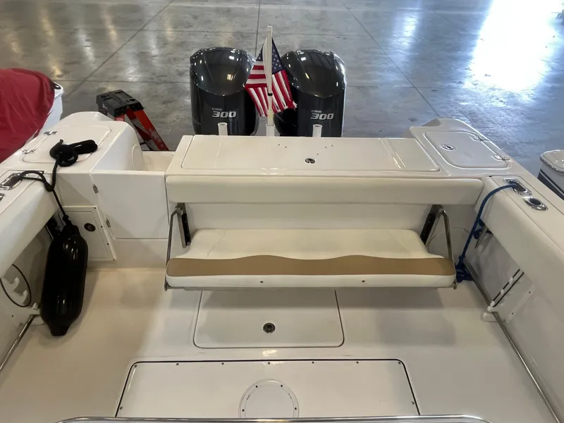Slide: The Image of 2020 Edgewater 320CC boat interior with seating, dual engines, and American flag. - 18