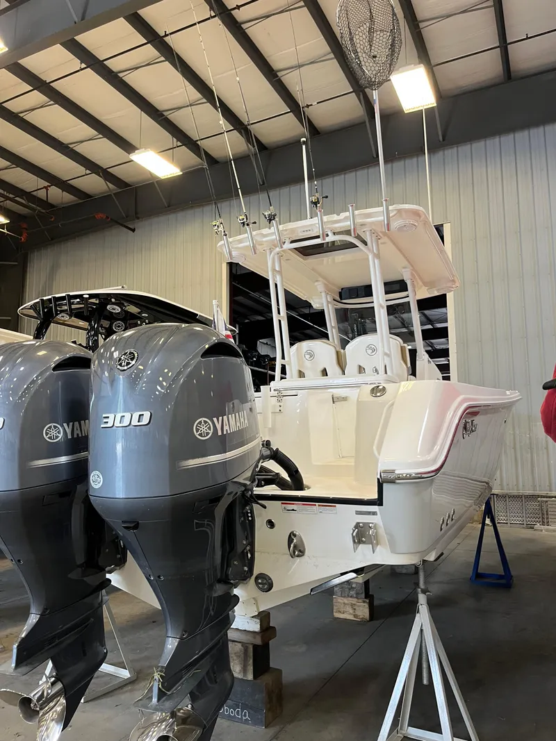 Slide: The Image of 2020 Edgewater 320CC boat with dual Yamaha 300 engines in a warehouse setting. - 25