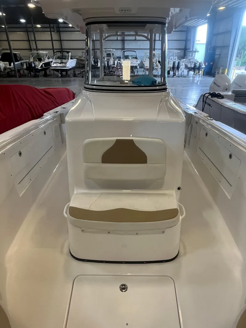 Slide: The Image of 2020 Edgewater 320CC boat interior in a showroom, featuring seating and helm station. - 8