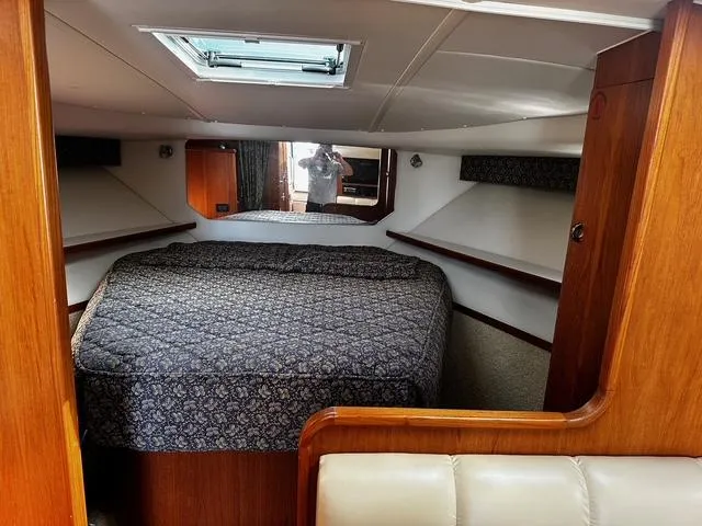 Slide: The Image of 2003 Tiara Yachts 3500 Express interior with leather seating, wooden cabinetry, and compact kitchen area. - 14