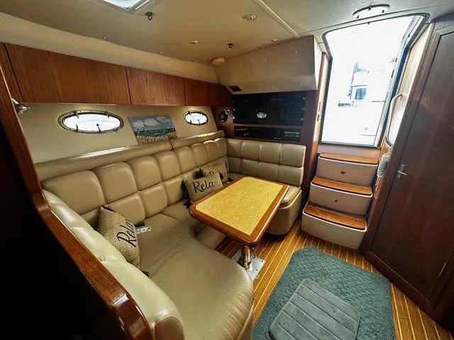 Slide: The Image of 2003 Tiara Yachts 3500 Express cabin interior with seating, table, and kitchenette. - 15