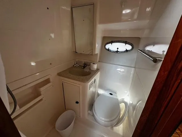 Slide: The Image of 2003 Tiara Yachts 3500 Express cabin interior with bed, wood accents, and overhead hatch. - 16