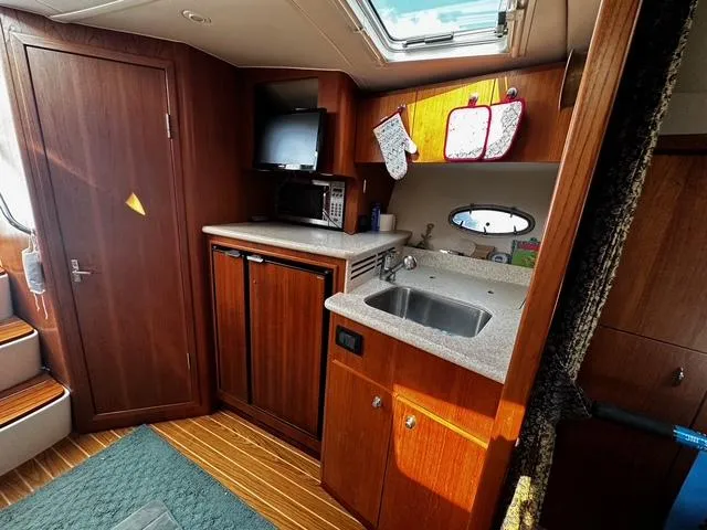 Slide: The Image of 2003 Tiara Yachts 3500 Express interior with leather seating, wooden table, and nautical decor. - 17