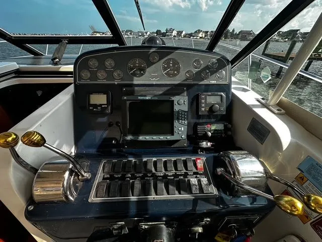 Slide: The Image of 2003 Tiara Yachts 3500 Express bathroom with toilet, sink, mirror, and porthole window. - 18