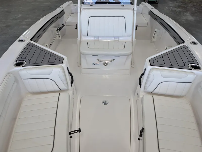 Slide: The Image of 2018 Yamaha Boats 210 FSH Sport interior with white seating and storage compartments. - 5