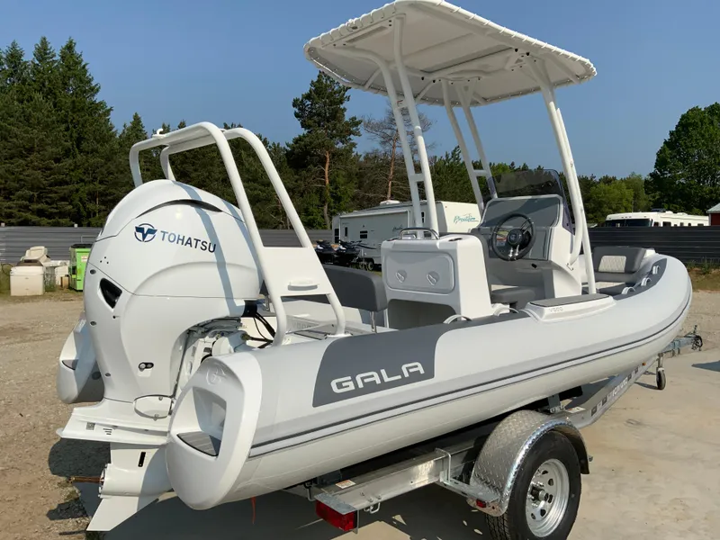Slide: The Image of 2026 Gala V500 boat with Tohatsu engine on a trailer, parked outdoors. - 10