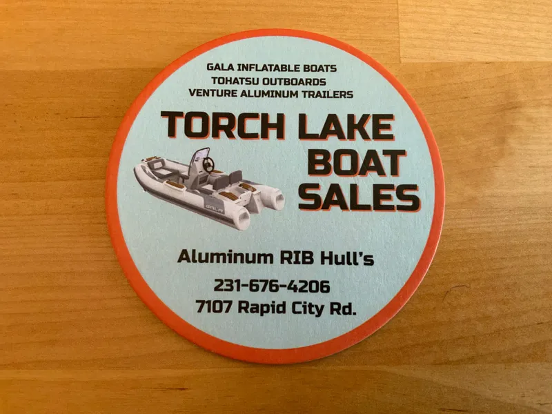Slide: The Image of Round coaster advertising Torch Lake Boat Sales with Gala inflatable boat image. - 16