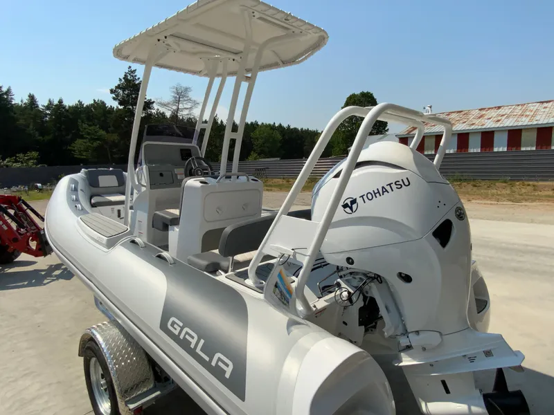 Slide: The Image of 2026 Gala V500 boat with Tohatsu engine on a trailer, parked outdoors. - 2
