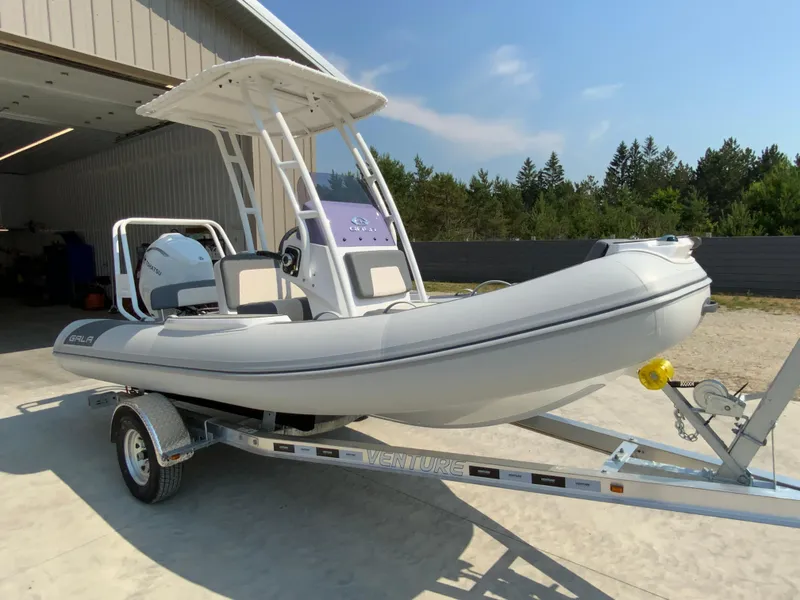Slide: The Image of 2026 Gala V500 boat on trailer, parked outside a garage, under clear blue sky. - 8