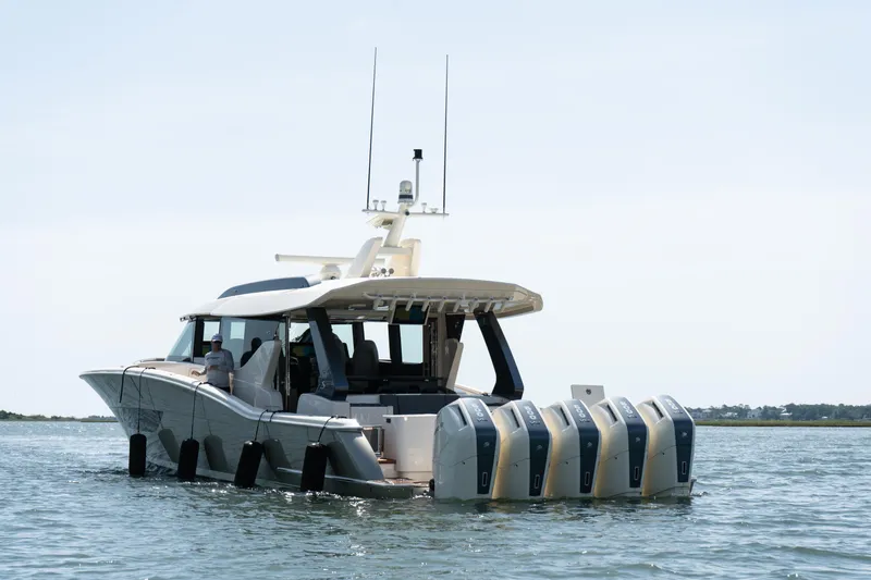 Slide: The Image of 2025 Scout 670 LXS boat with multiple engines on calm water. - 2