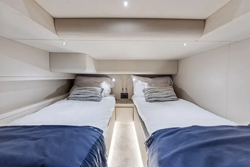 Slide: The Image of Luxurious twin cabin interior of 2025 Scout 670 LXS yacht, featuring modern bedding and ambient lighting. - 6