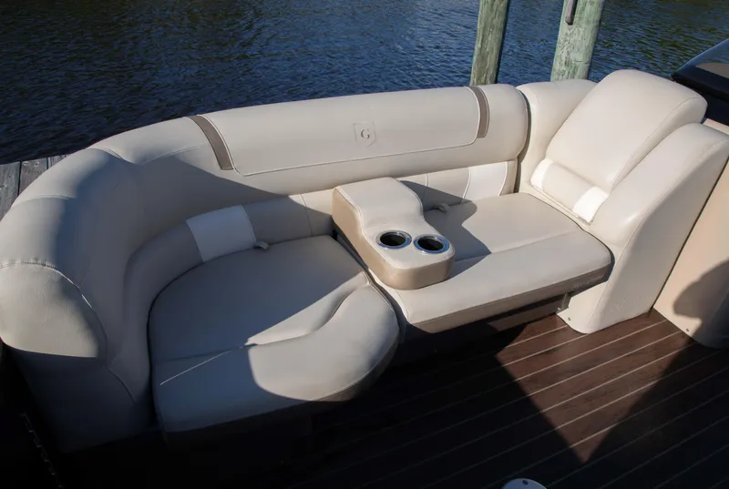 Slide: The Image of Luxurious seating on 2018 Godfrey 255 ULB boat with cup holders, docked by water. - 13